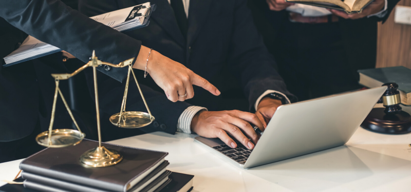 Desk with Justice Scales with Books and Laptop