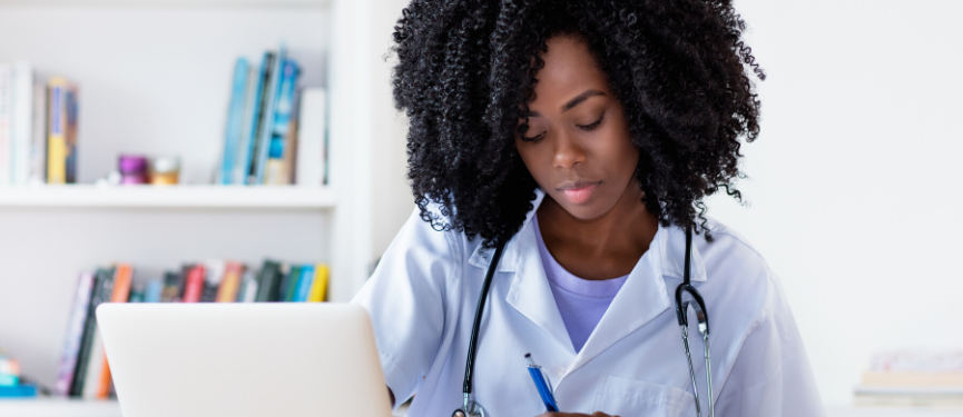 Nurse Studying with Laptop Looking Down Taking Notes